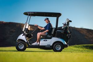 Create high school senior portrait. Lifesyle photo of high schooler sitting in a golf cart on the golf course.