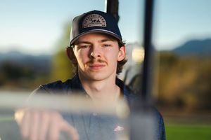 Senior portrait photography by Dusty Wooddell. High School senior sits in gold cart.