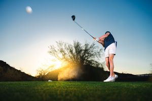 Action portrait of high school senior playing gold. Senior portraits by Dusty Wooddell.