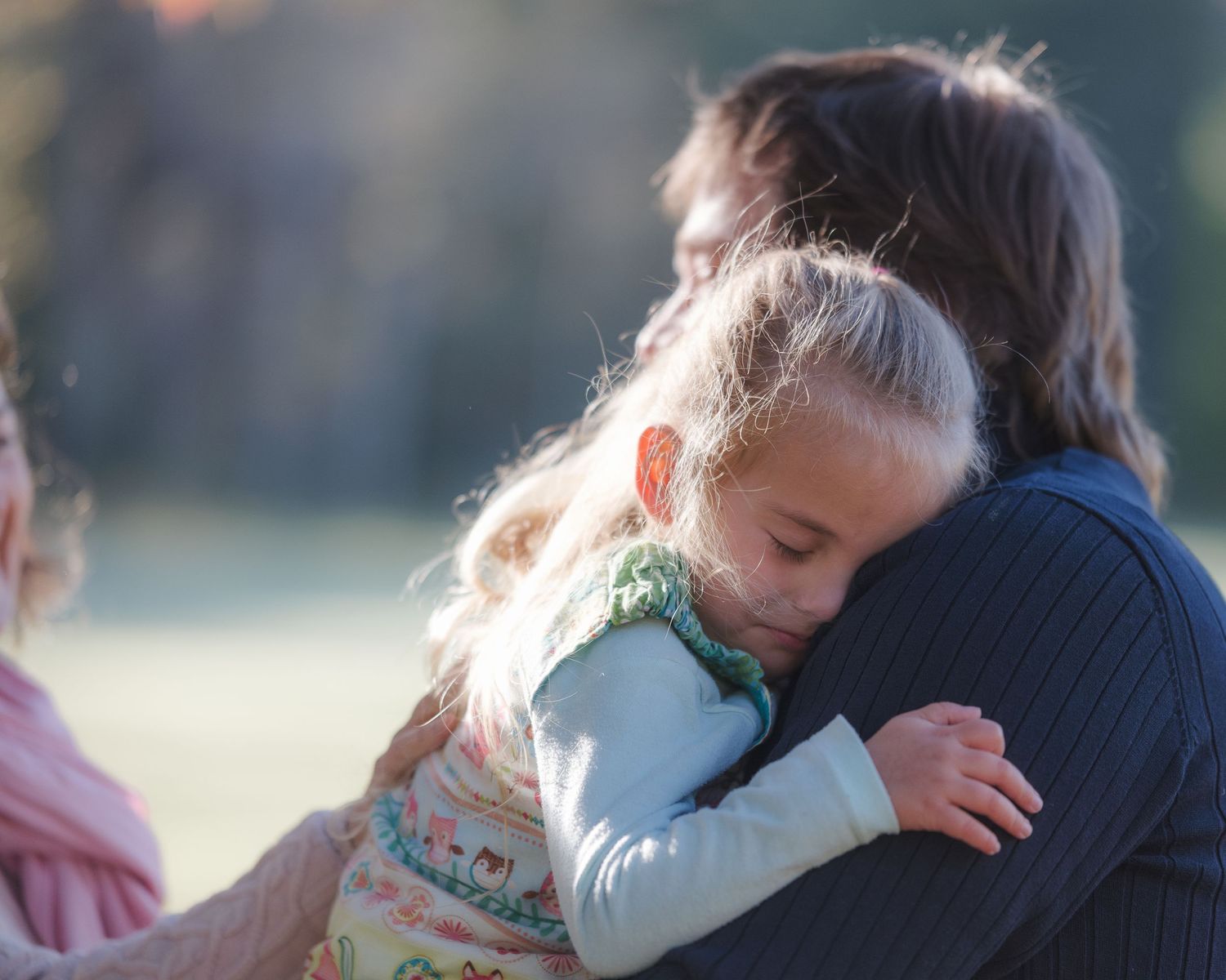 Tender outdoor family moment captured in soft natural lighting.