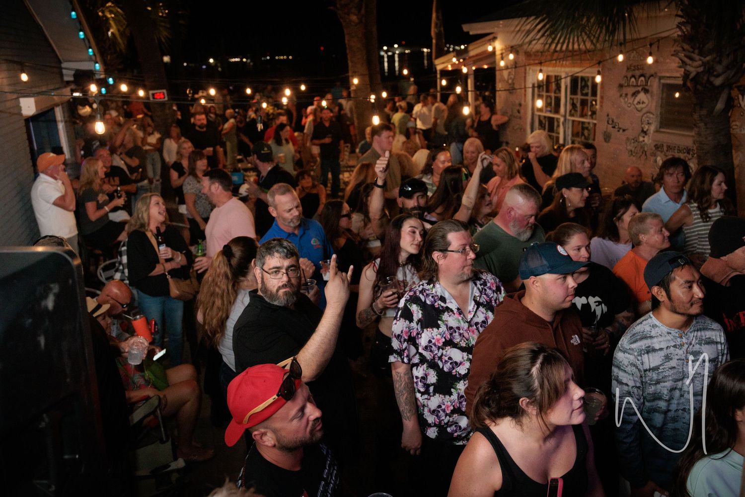 A packed crowd raises their hands during a lively nightclub performance.