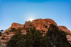 sun peeking from the top of a rock formation in Grand Junction, Colorado