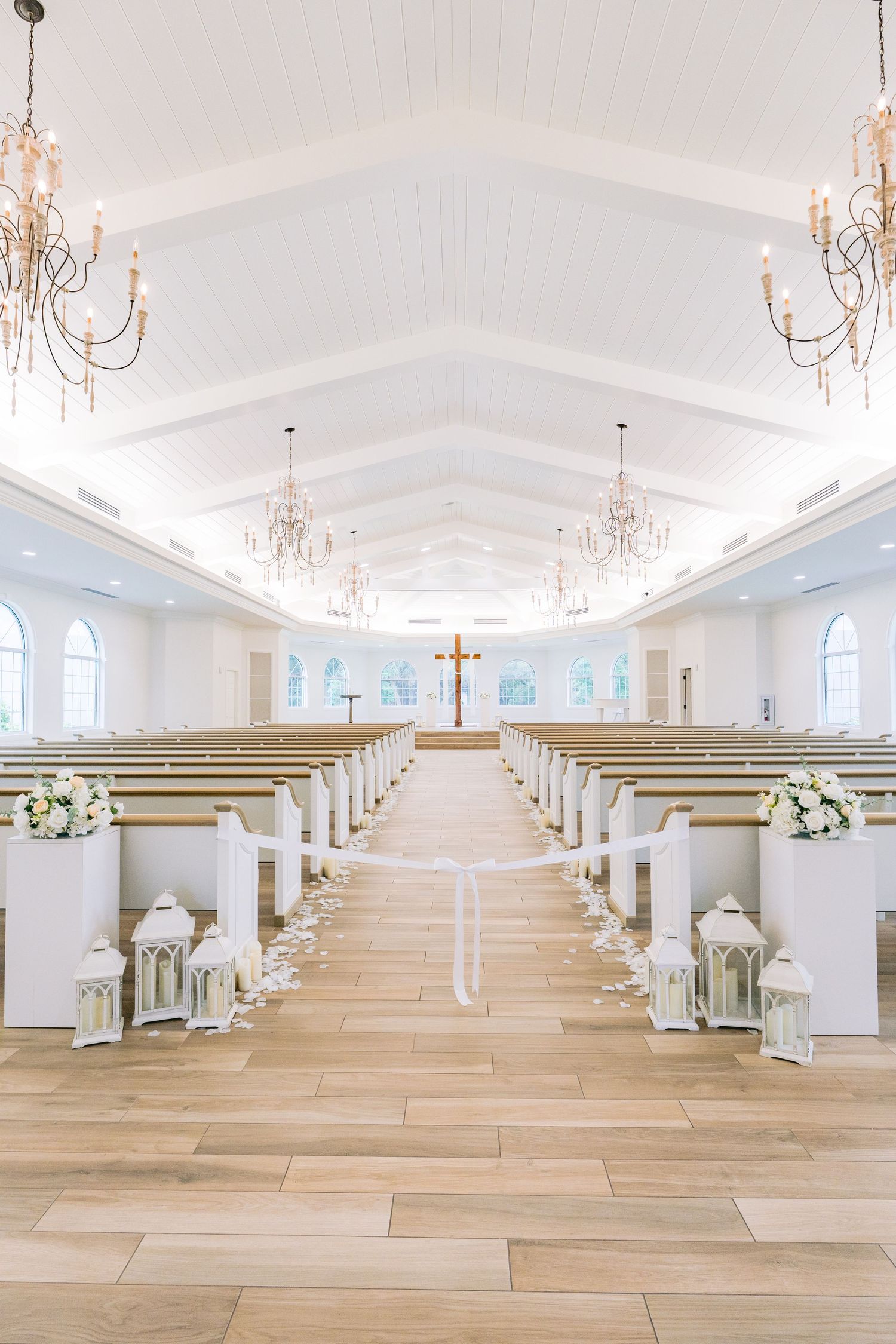 Harborside Chapel, Safety Harbor, Florida. Elegant white church interior with crystal chandeliers, arched windows.