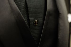 Black leather car interior seats with perforated pattern and detailed stitching details shown in closeup.