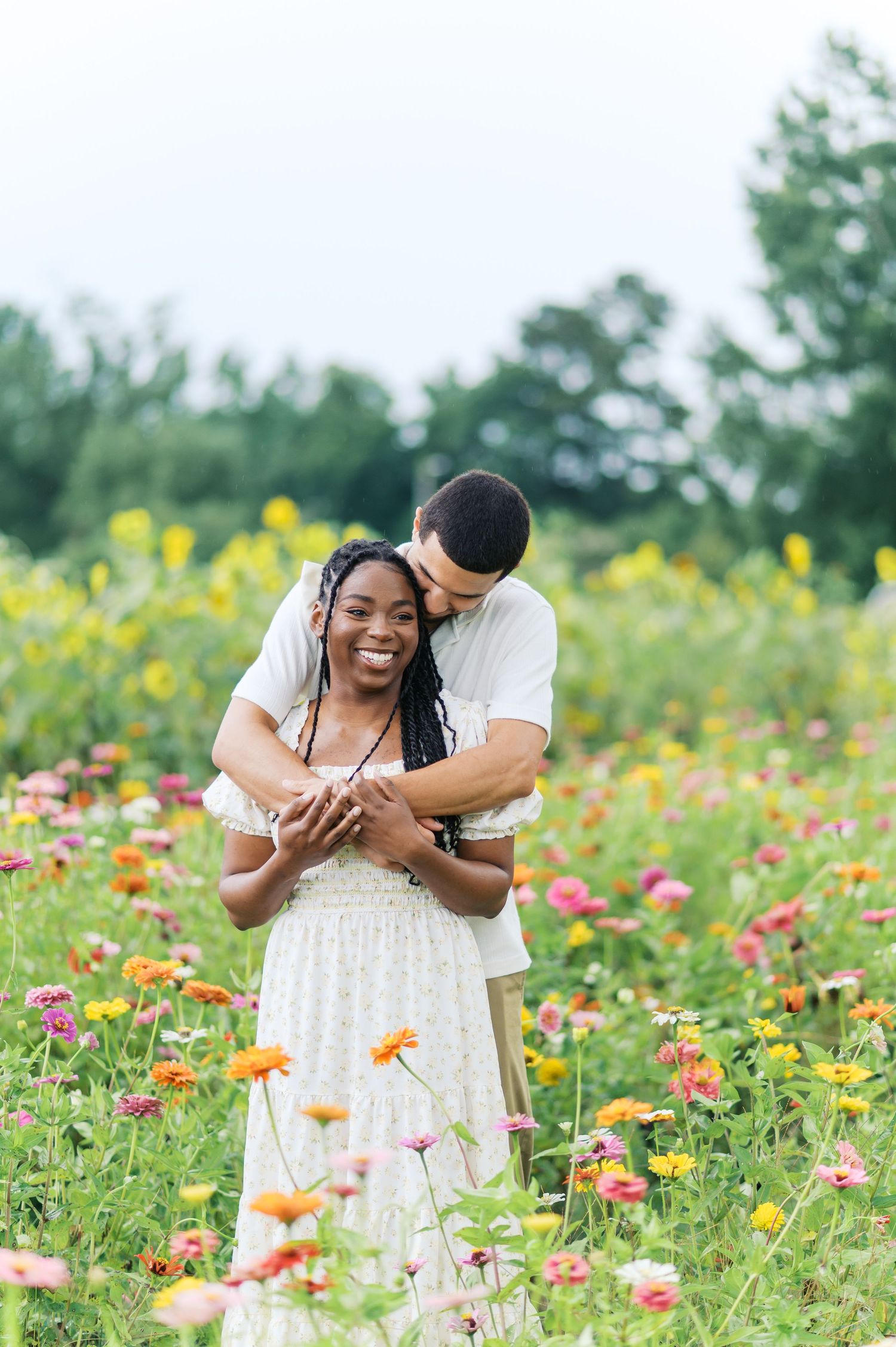 Romantic engagement photoshoot series in a vibrant wildflower field with orange and yellow blooms.