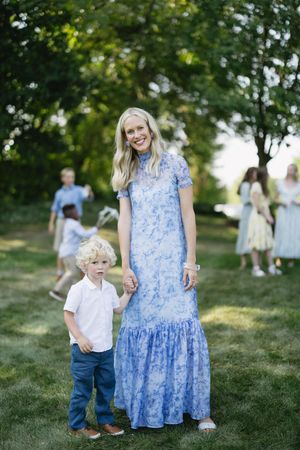 A series of candid outdoor family photos showing people in blue and white clothing on a grassy hillside in summer.