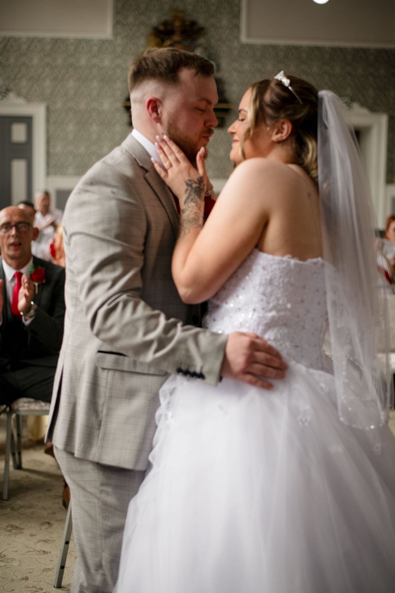 A tender moment between newlyweds sharing their first dance at a wedding reception, with the bride in a white gown.