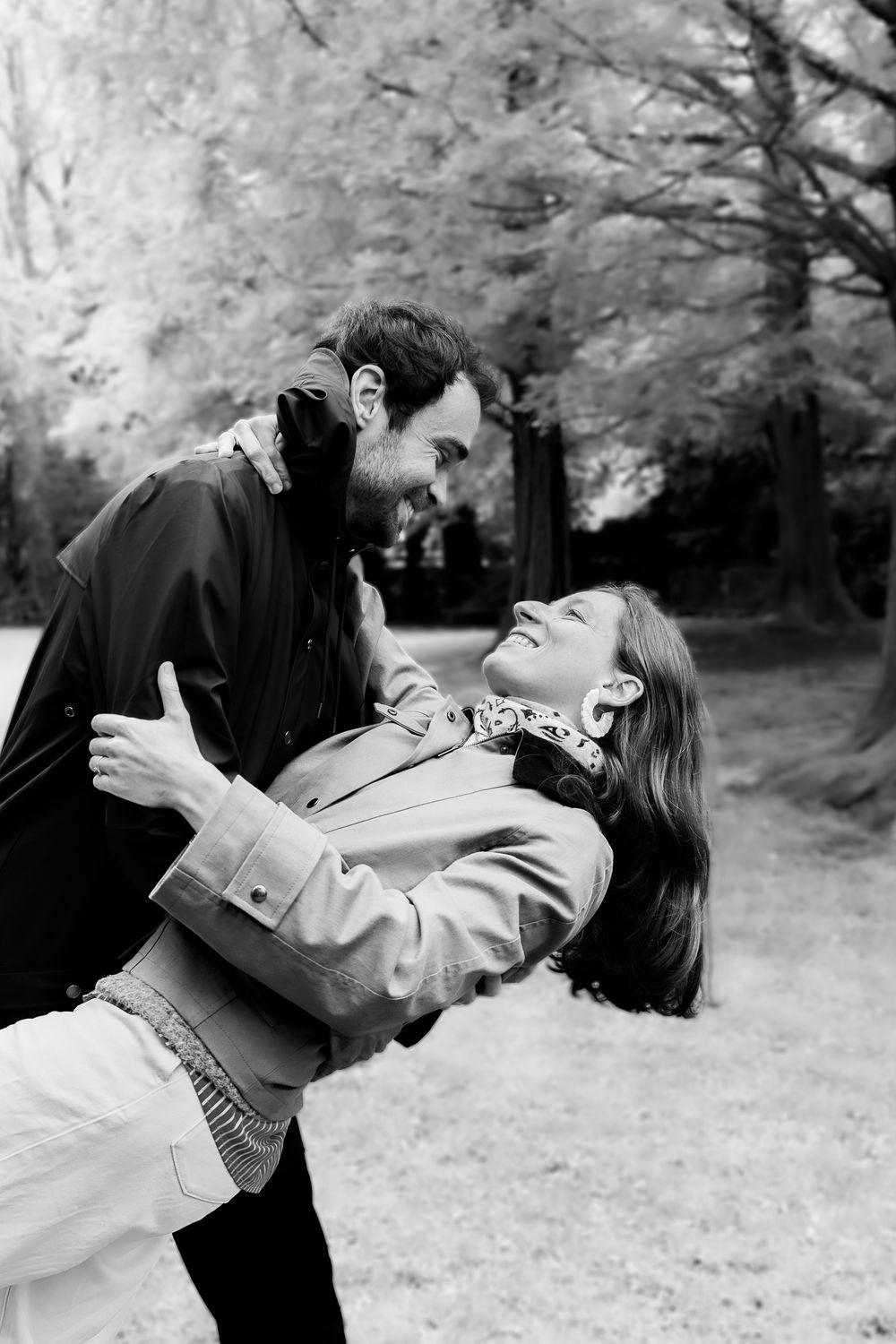 Black and white photo of a man dipping a laughing woman in a romantic outdoor dance.