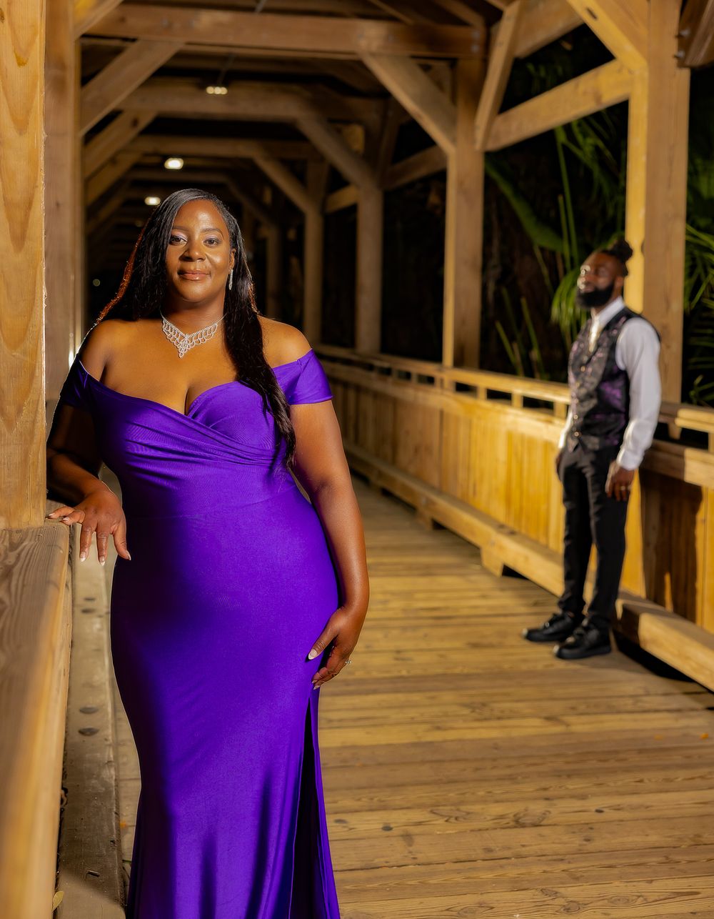 Elegant photo series in wooden covered walkway with stunning purple dress.