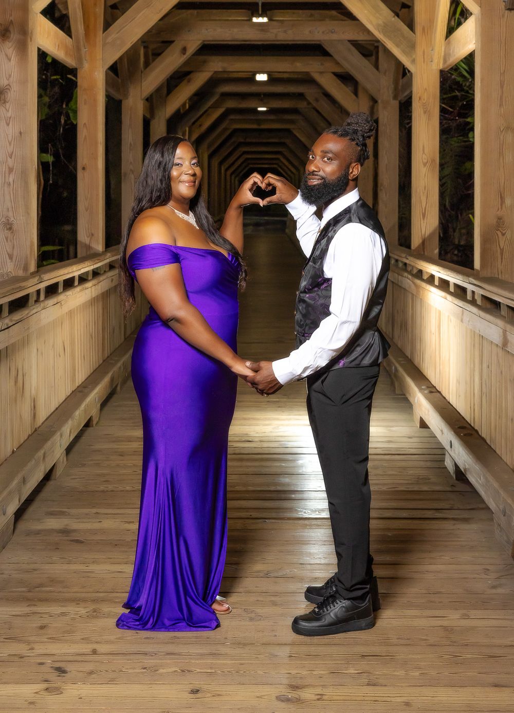 Romantic couple photoshoot in wooden covered bridge with purple gown and formal vest.