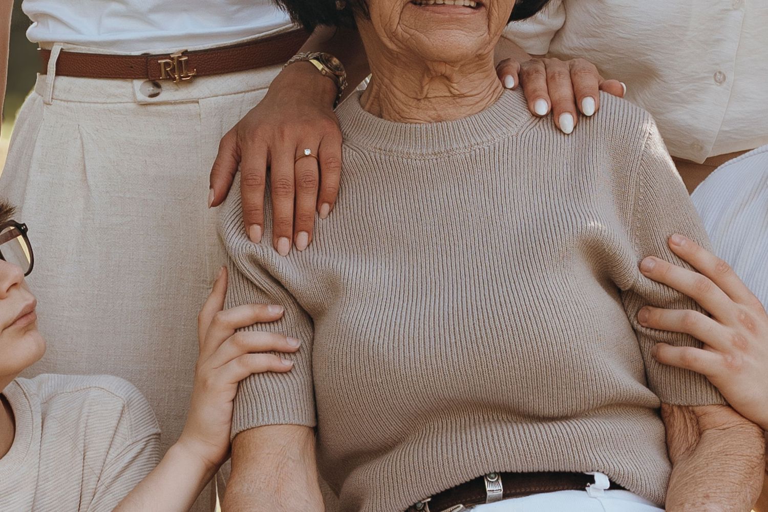 Tender moment between parent and sleeping infant in white clothing.