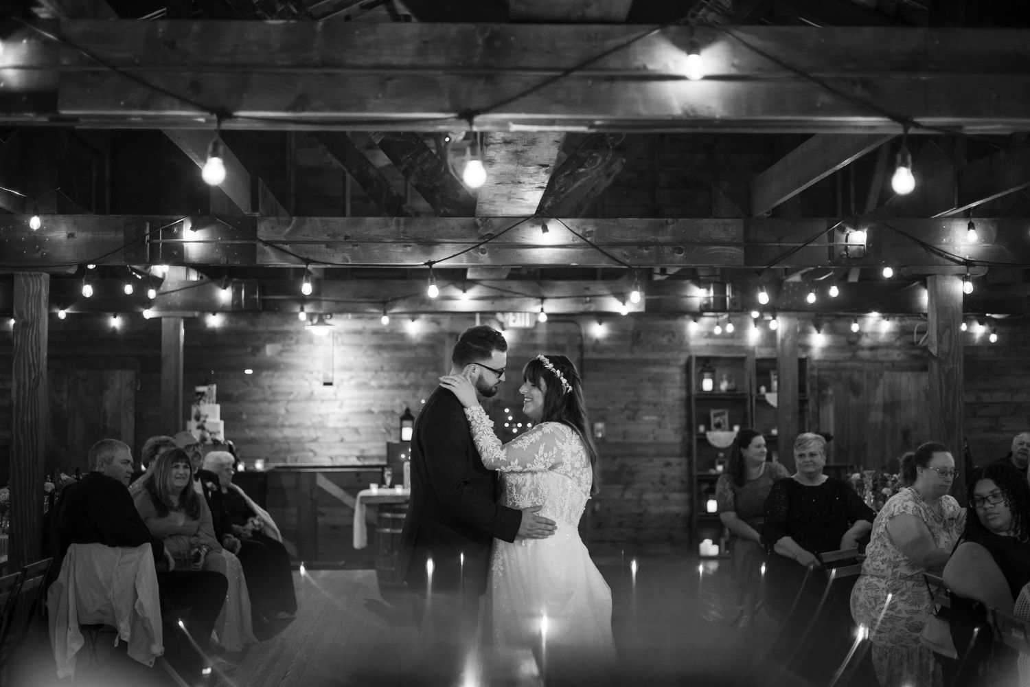 String lights illuminate a rustic indoor venue with an industrial-chic ambiance.