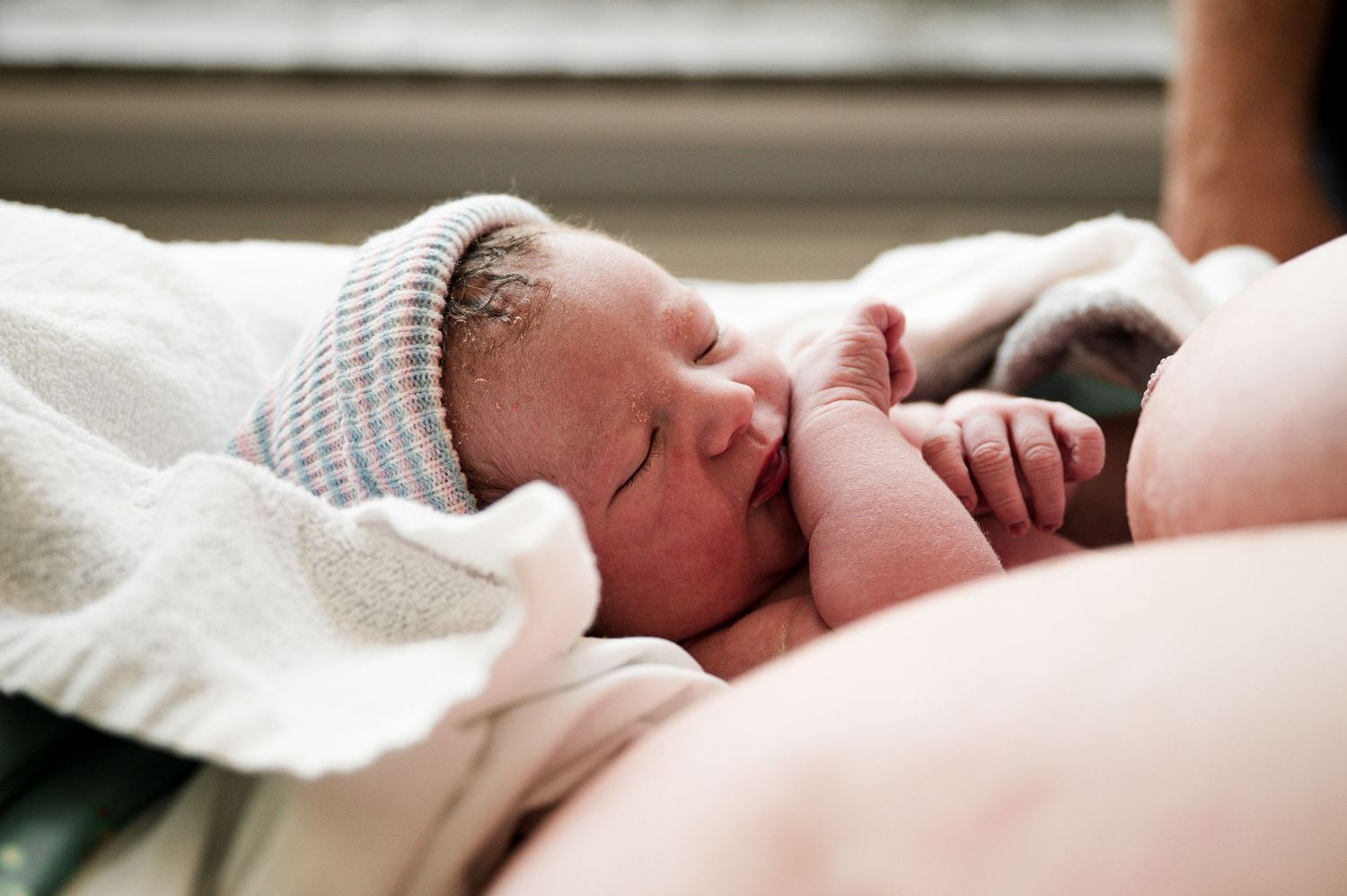 A series of peaceful images showing a sleeping newborn baby in soft white blankets and natural lighting.