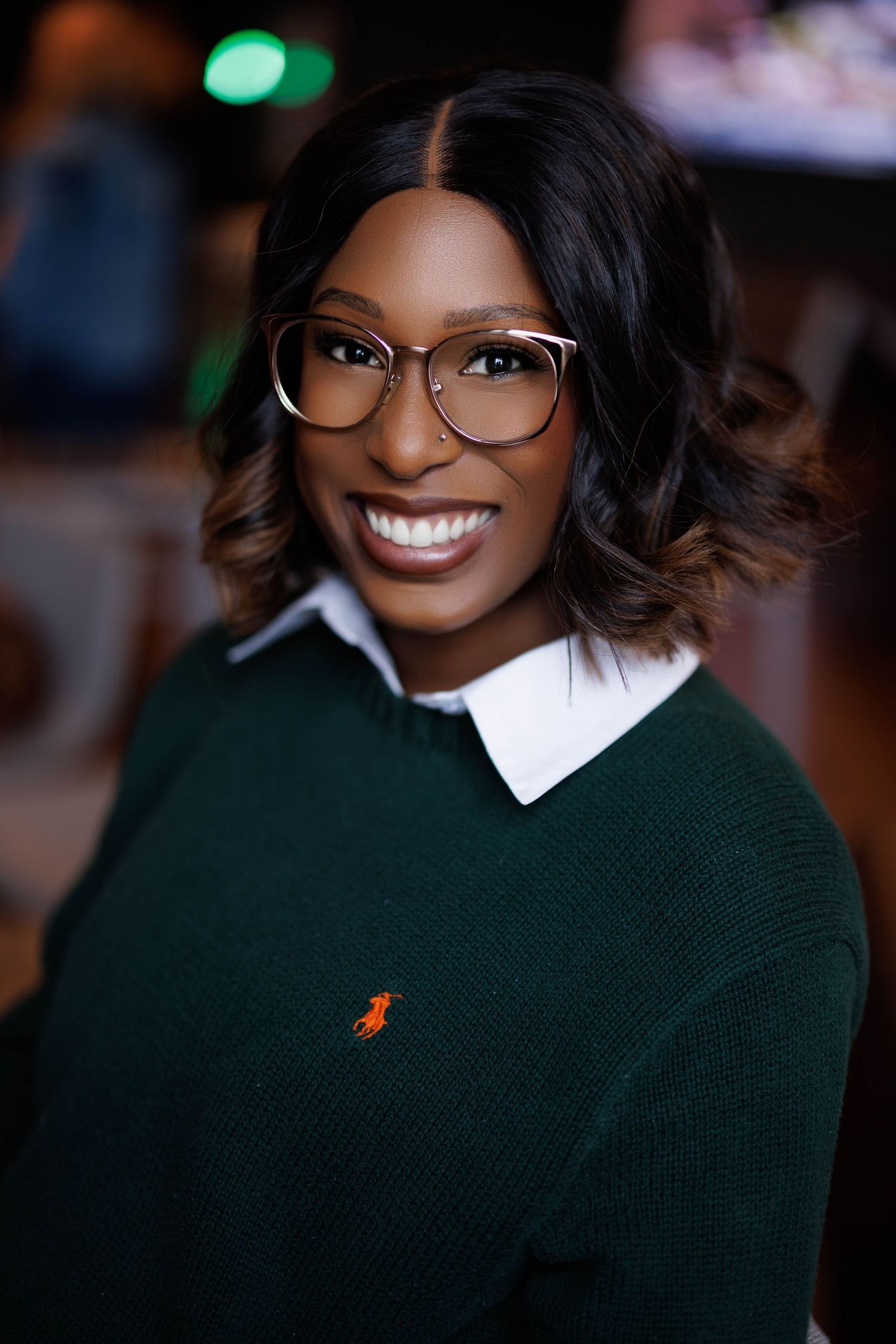 Professional headshot of a smiling woman with shoulder-length brown hair, wearing a blue blouse against a neutral background.