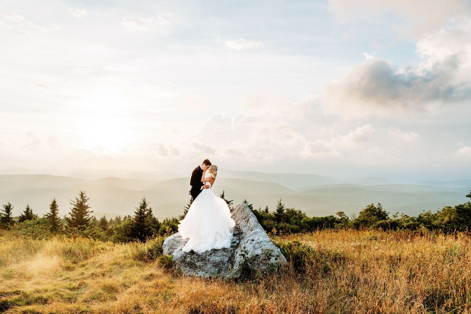 Bride and groom share a kiss at sunset in the field of Spruce Knob Mountain during their elopement | west virginia elopement photographer