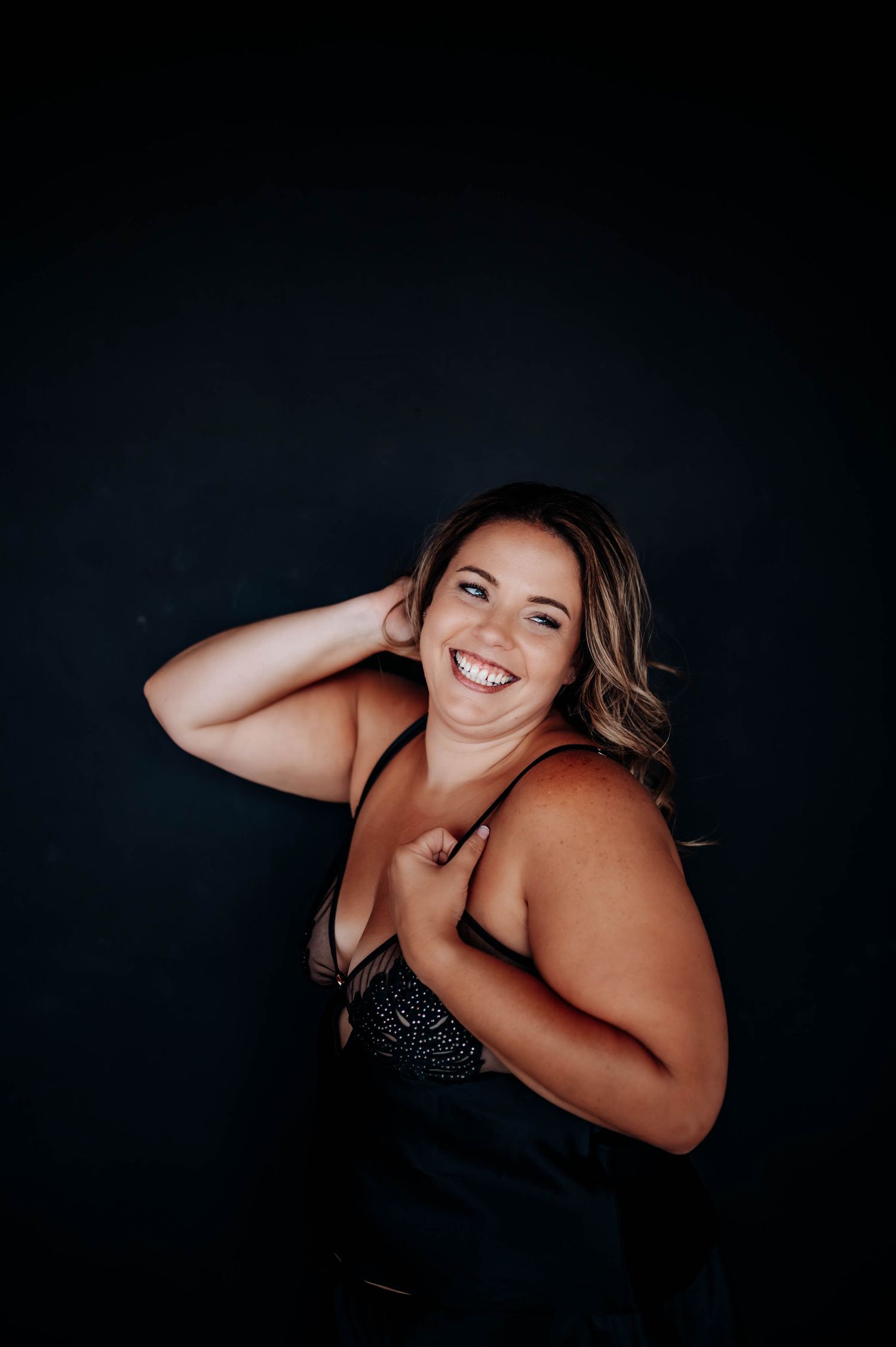 Artistic boudoir photography series showing silhouetted feminine figure in black lingerie against dark background.