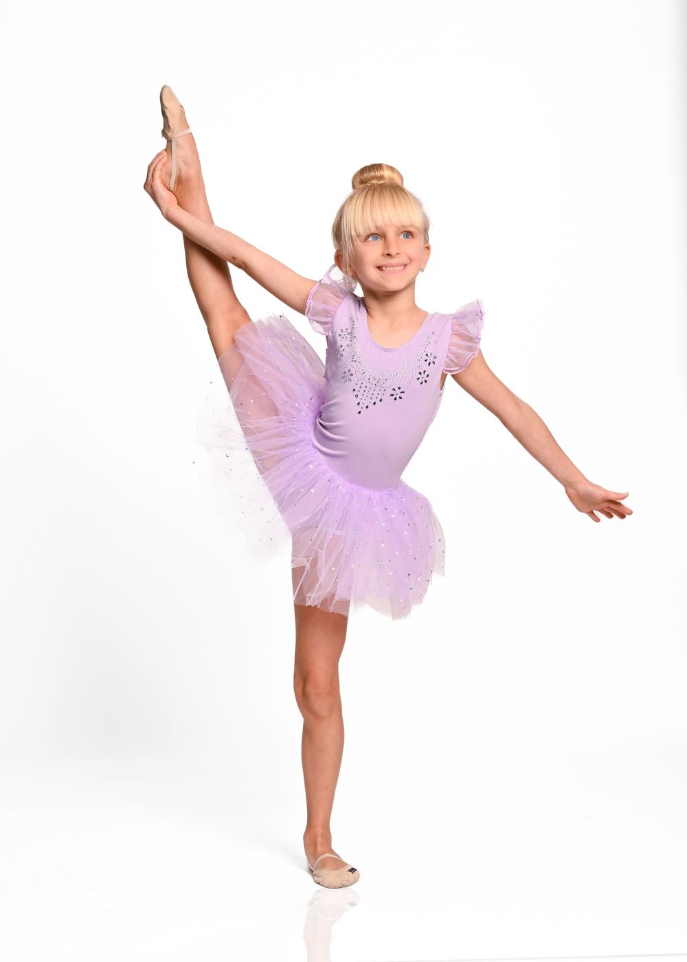 Young dancer in purple tutu leotard performs graceful ballet poses in four sequential studio shots.