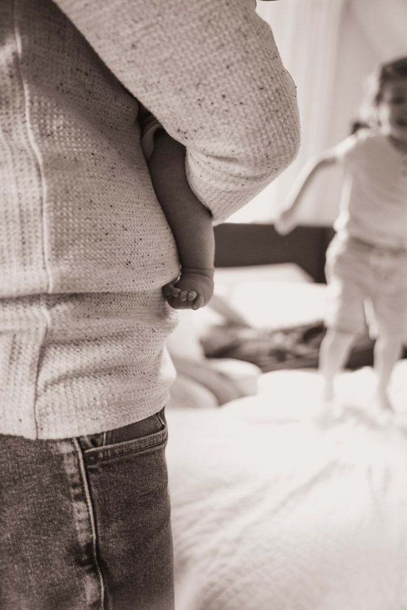 Sleeping baby in dad/s arms during a newborn lifestyle session in Northbook.