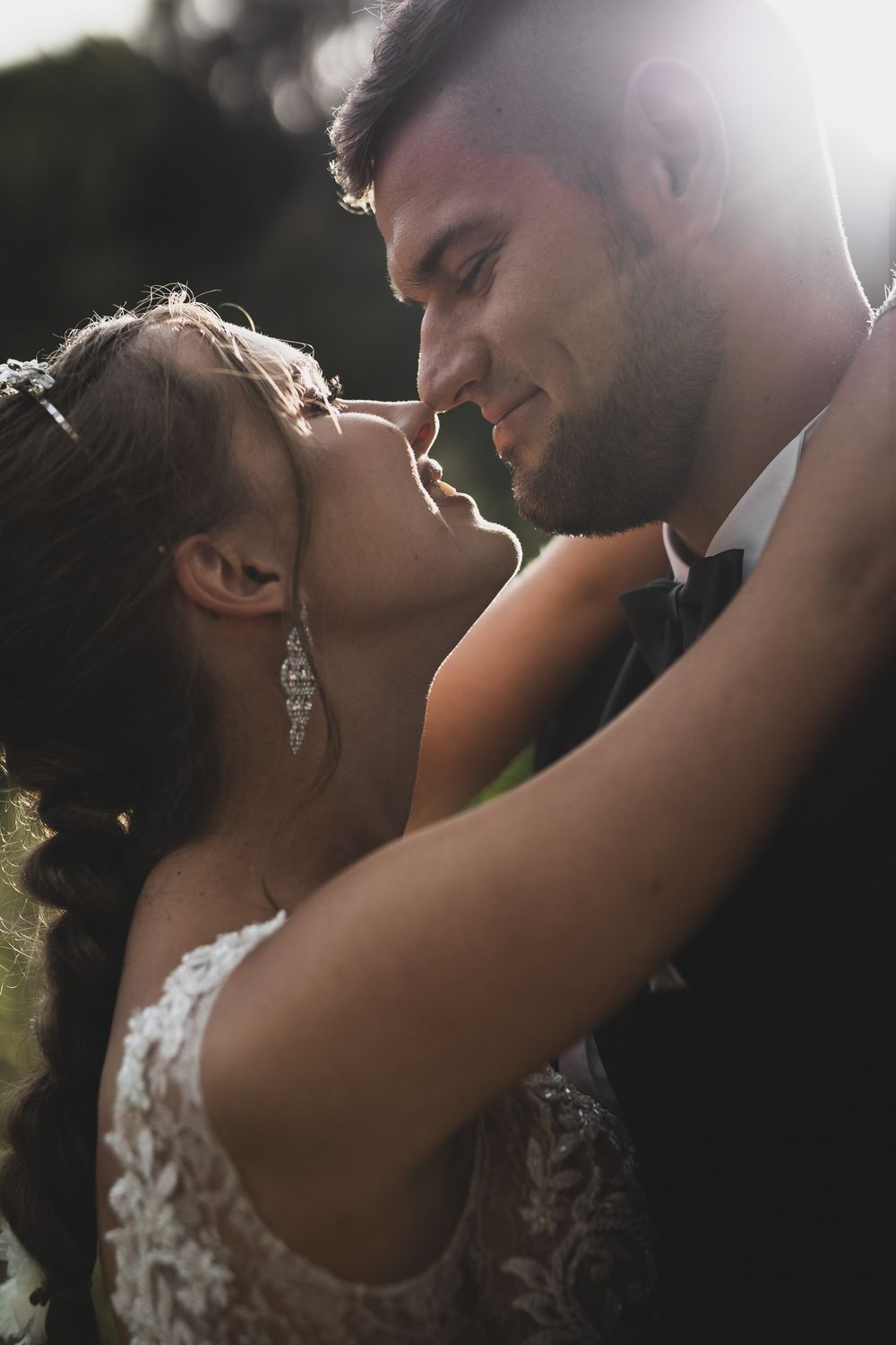 Romantic close-up portrait of couple in wedding attire during golden hour.