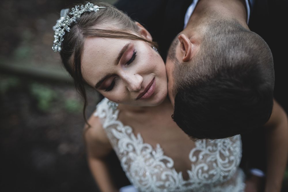 Tender moment between newlyweds captured in soft natural lighting.