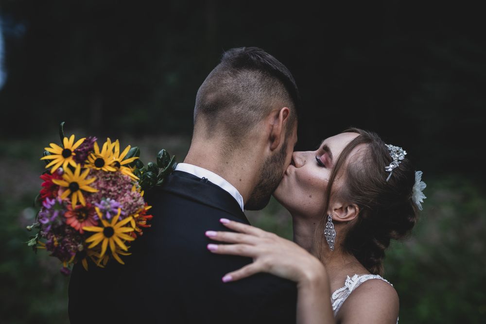 Intimate wedding portrait with sunflowers and natural outdoor lighting.