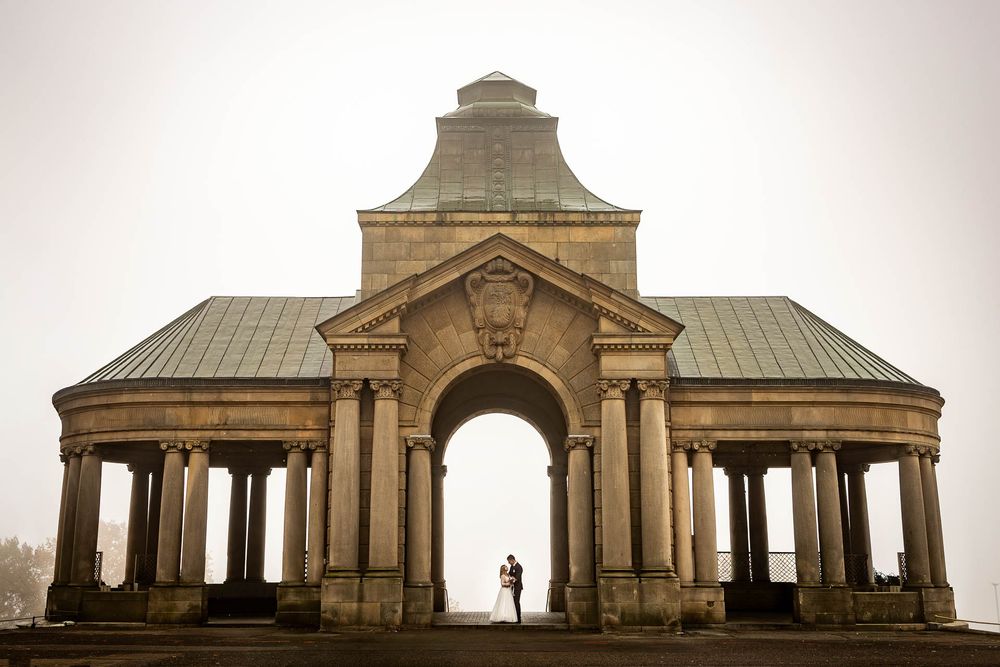 Classical stone architecture with columns and arches in a panoramic view.