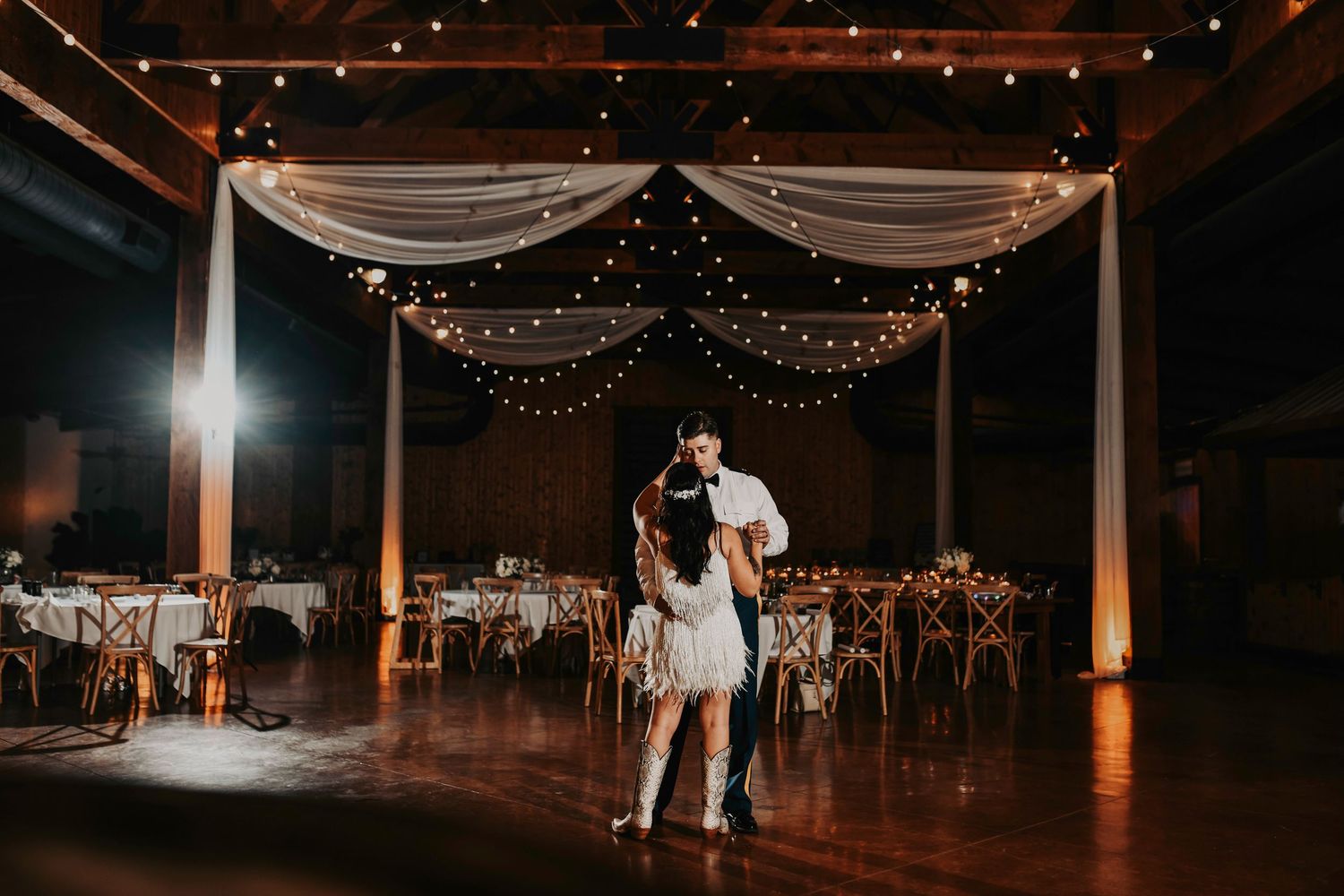 Romantic last dance moment with bride and groom under dim lights before their send-off.