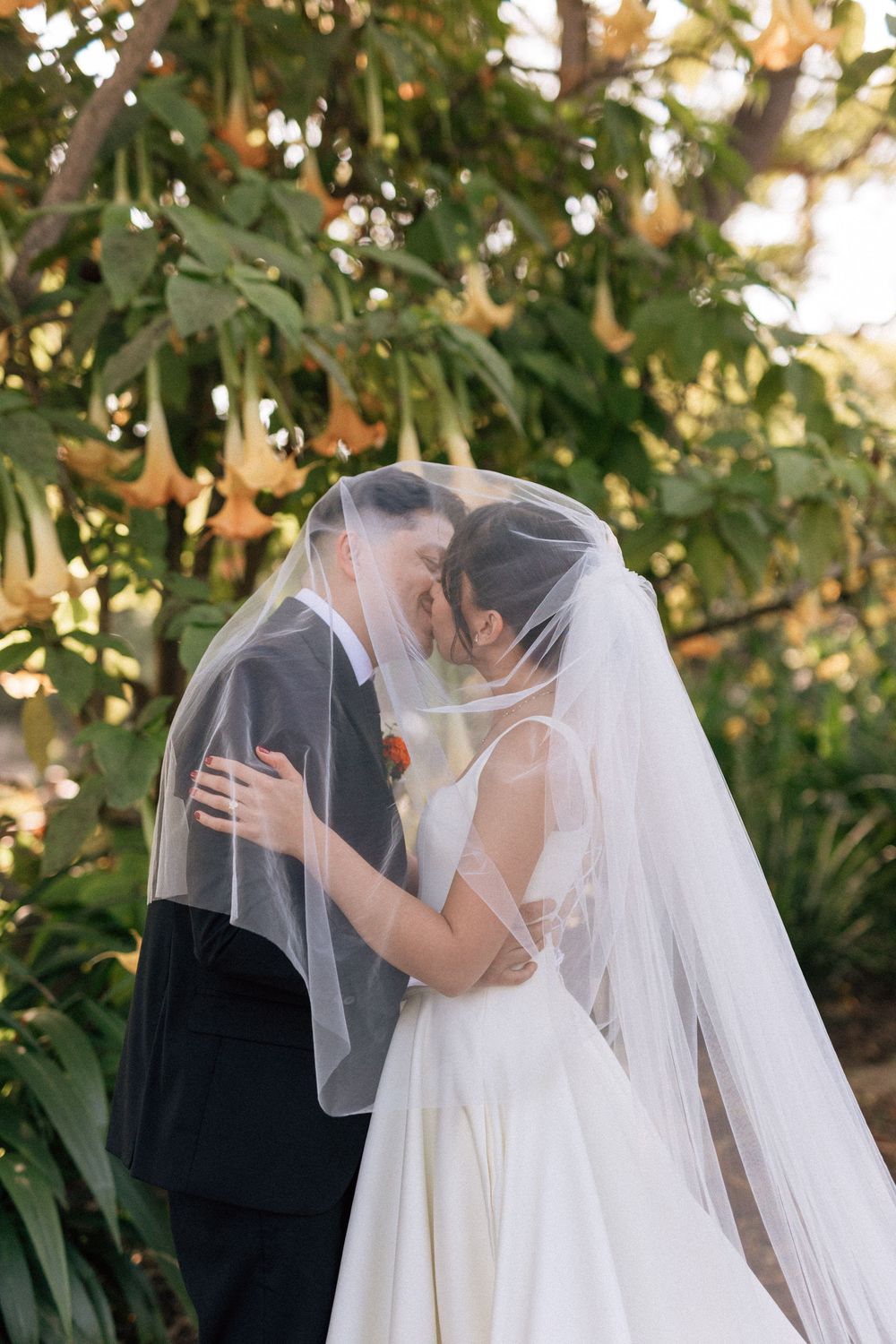 Santa Barbara wedding photographer captures bride and groom under a wedding veil sharing an intimate kiss.