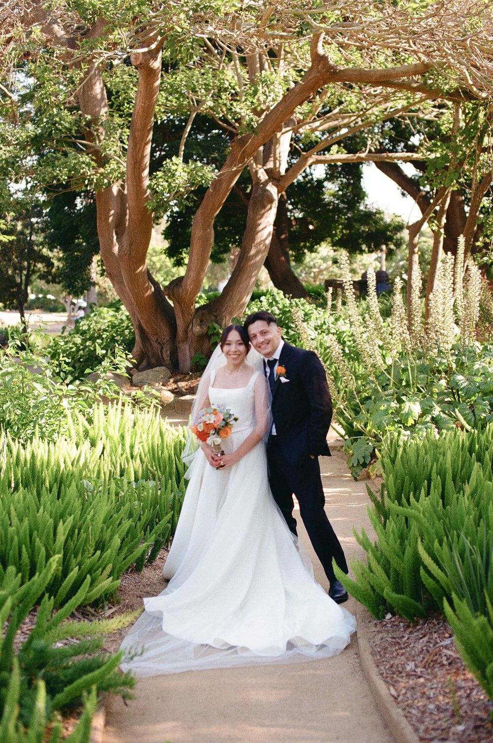 A colorful digital photo by Santa Barbara wedding photographer in Alice Keck Memorial Park showcasing a bride and groom smiling.