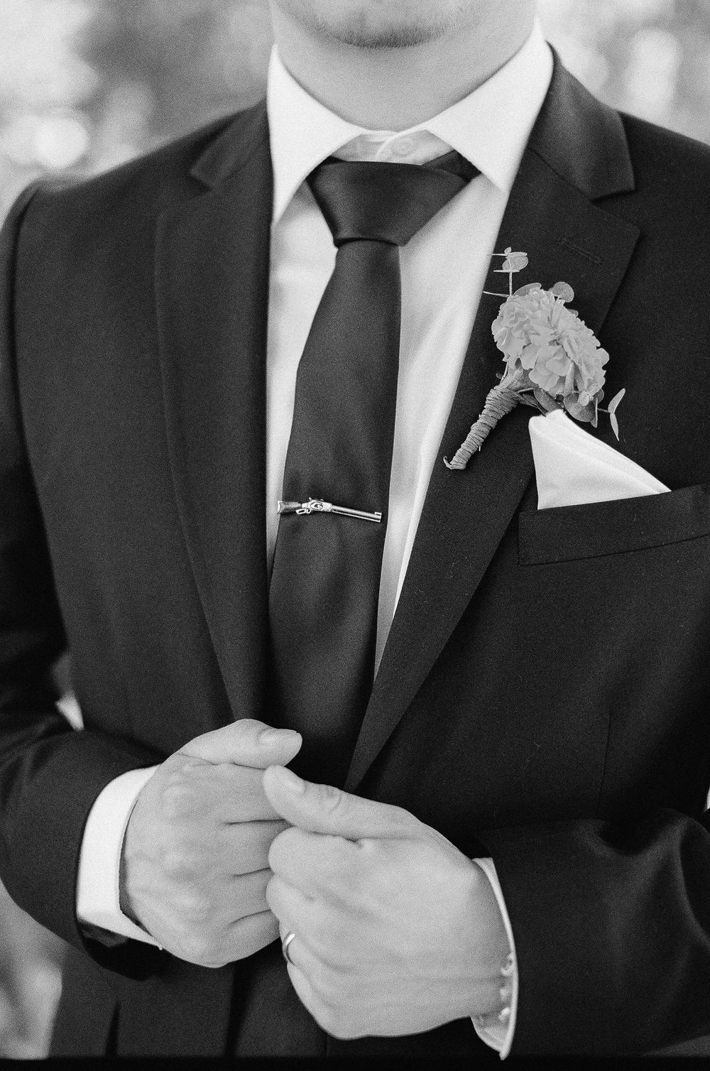 An artistic film photo of a groom showing his tie and boutonniere in Santa Barbara wedding