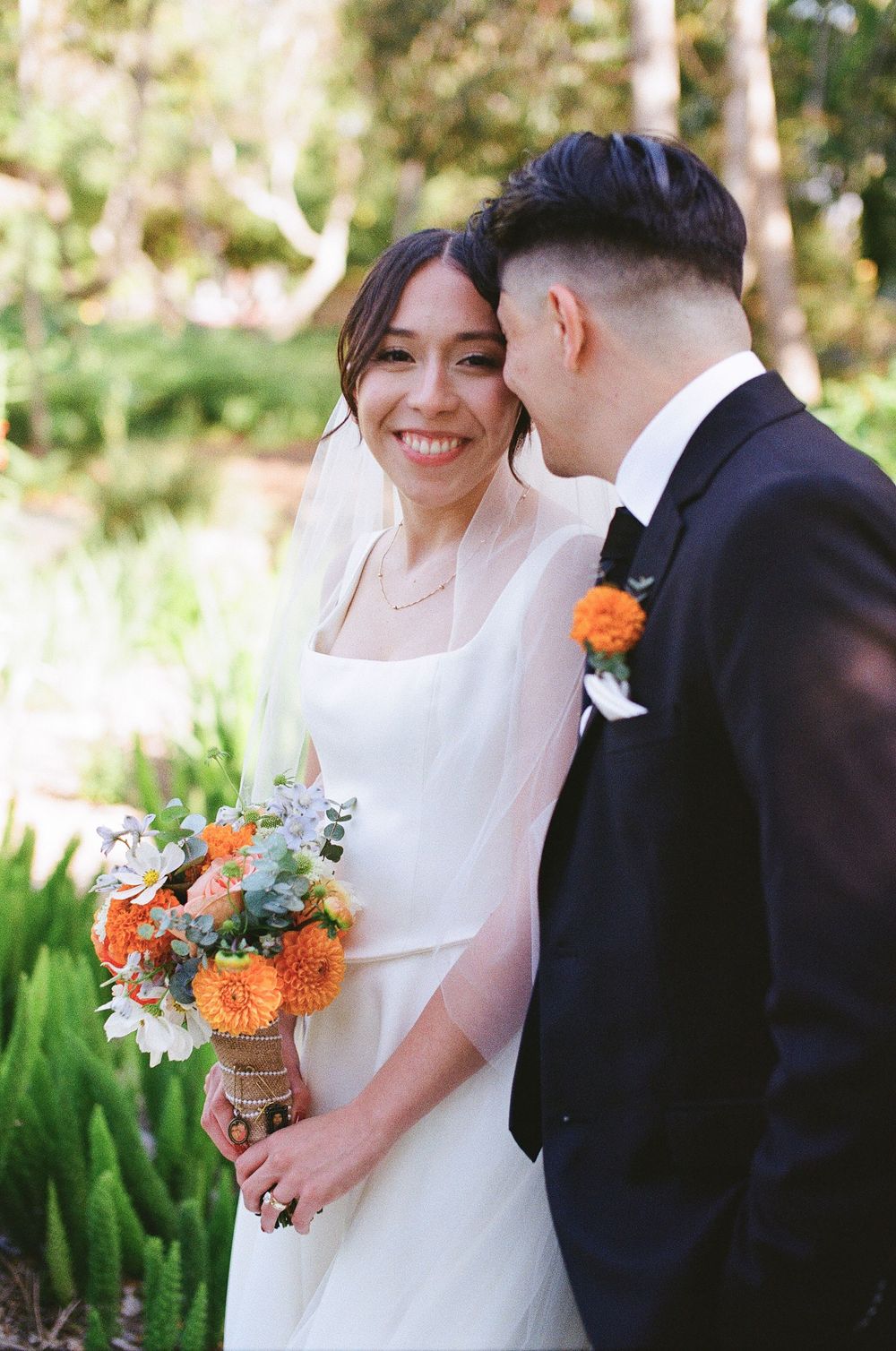 Santa Barbara wedding photographer captures the bride smiling in a warm film portrait at Alice Keck Memorial Garden.