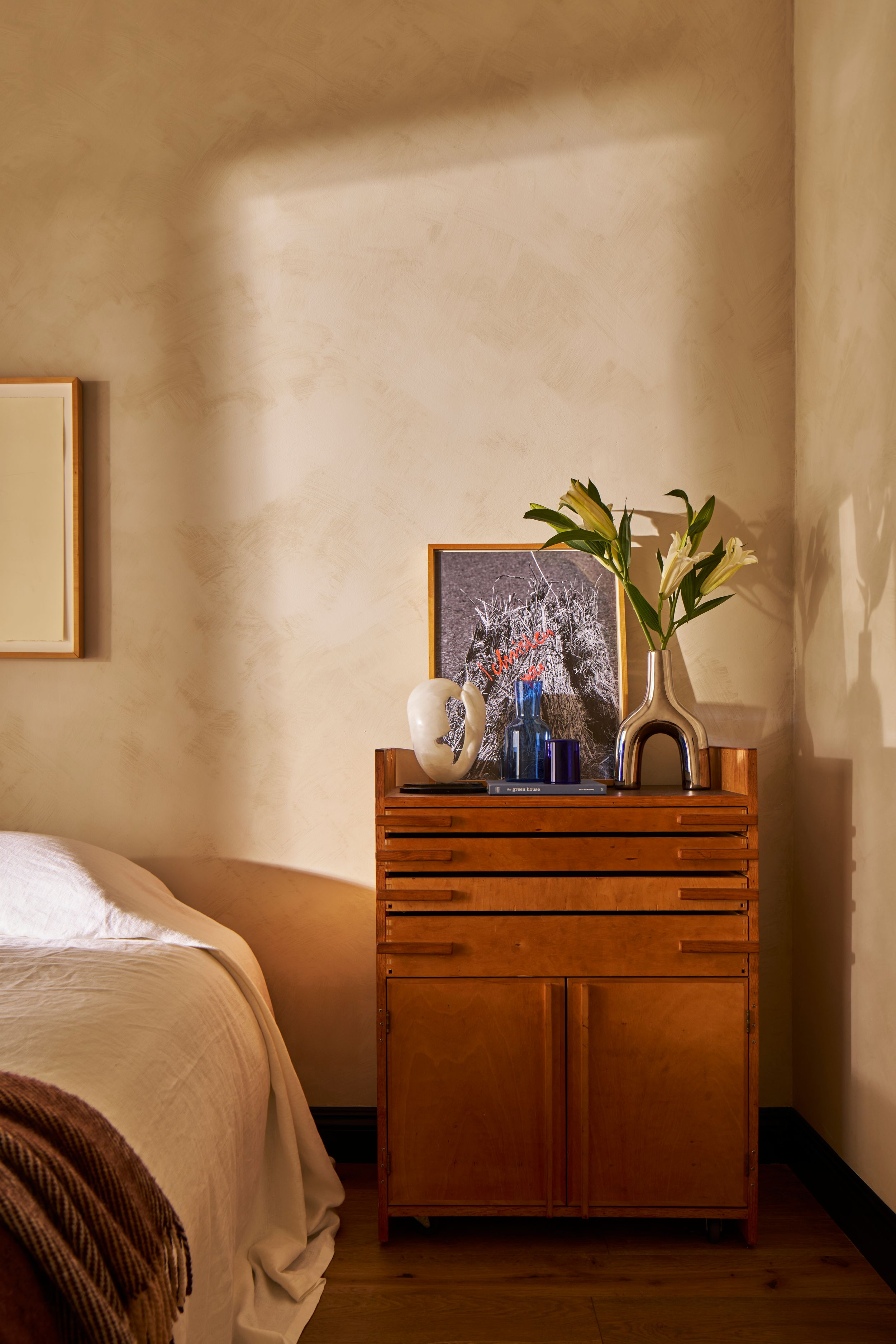 A wooden dresser against a beige wall with framed photos and plants, shown in a sequence of five similar angles.