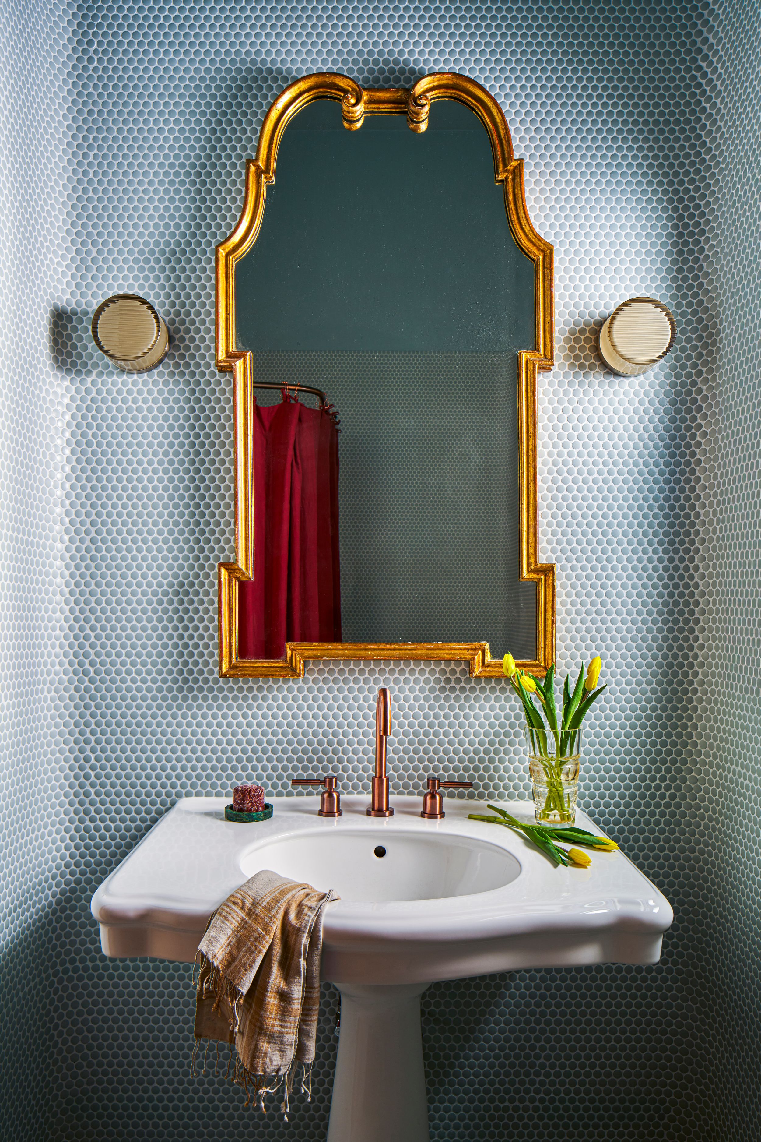 Elegant bathroom vanity with ornate gold-framed mirror against teal wallpaper featuring yellow tulips in a vase.