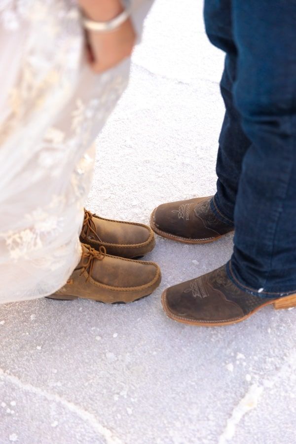 Close-up view of brown leather boots with jeans on a snowy surface showing multiple angles of footwear.