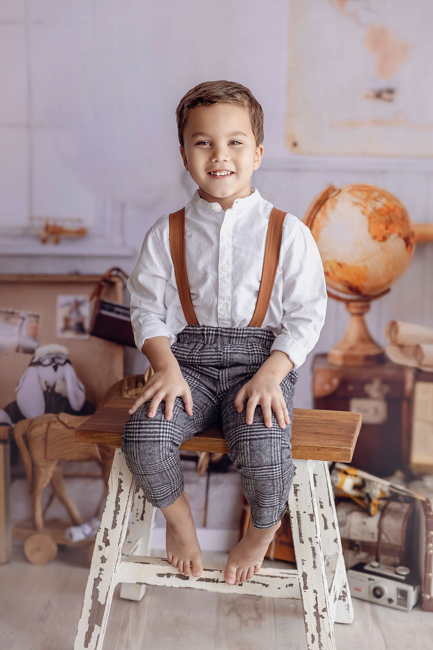 Nino de 5 anos es Fotografiado en el estudio de Detres Photography en Ponce tiene un atuendo con tirantes y el escenario es de explorador