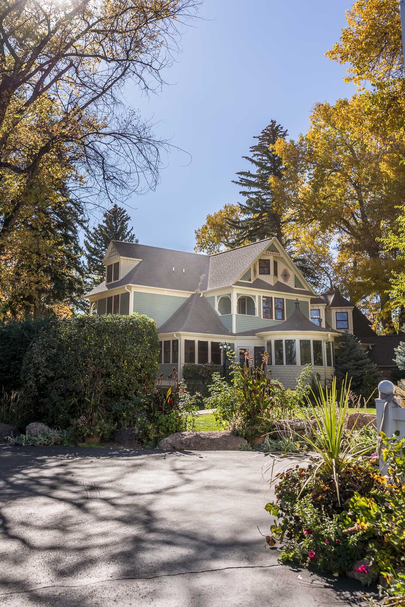 White suburban house with fall foliage and landscaping viewed from different angles in a photo collage.