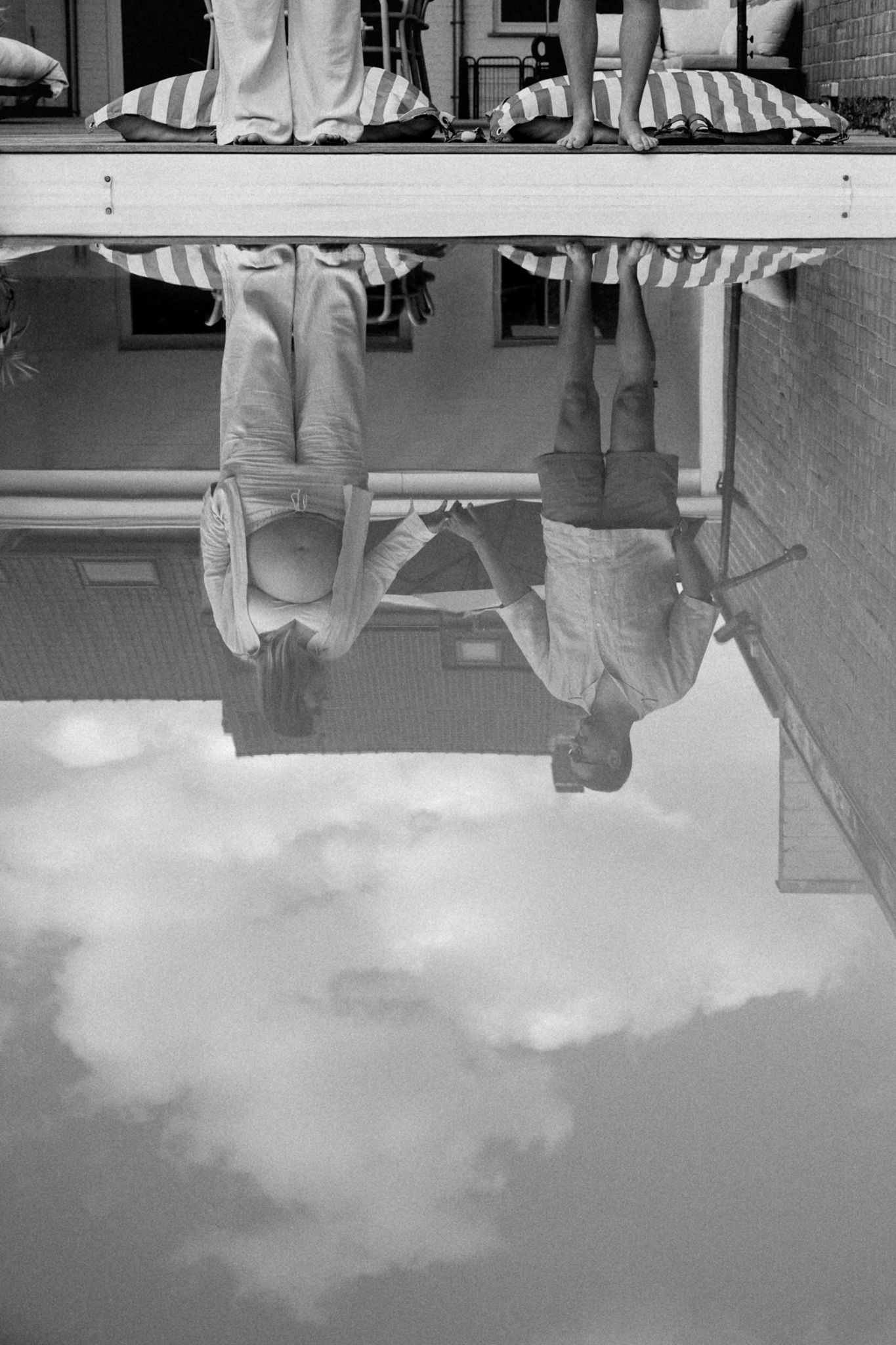 Reflets du couple dans l’eau de la piscine, seance photo grossesse Lille a domicile, mettant en valeur la complicite et les gestes tendres.