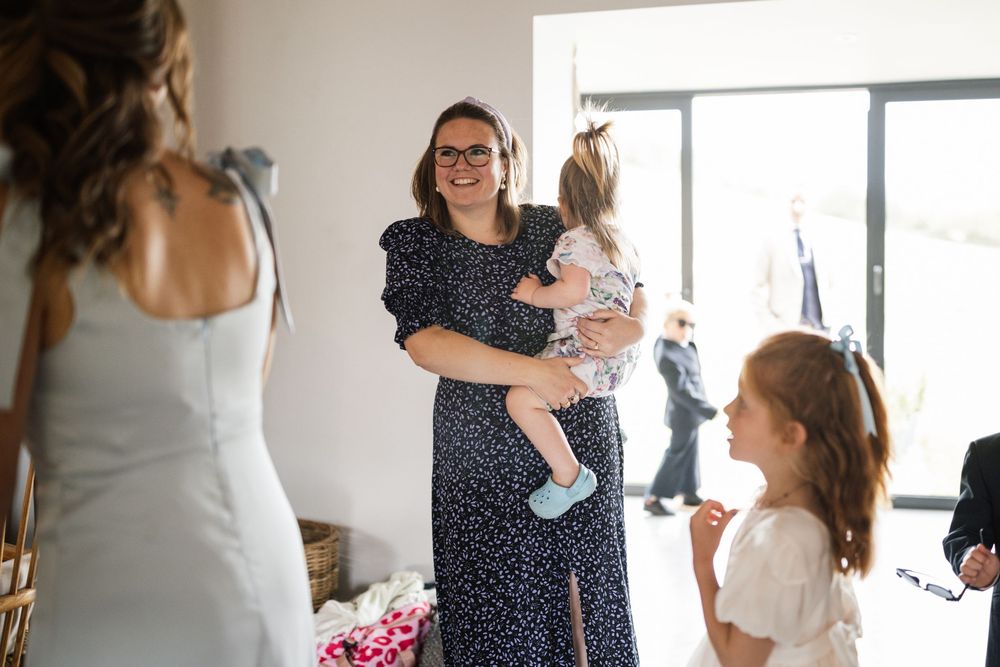 A series of candid moments showing people interacting and embracing in a bright, modern interior space.