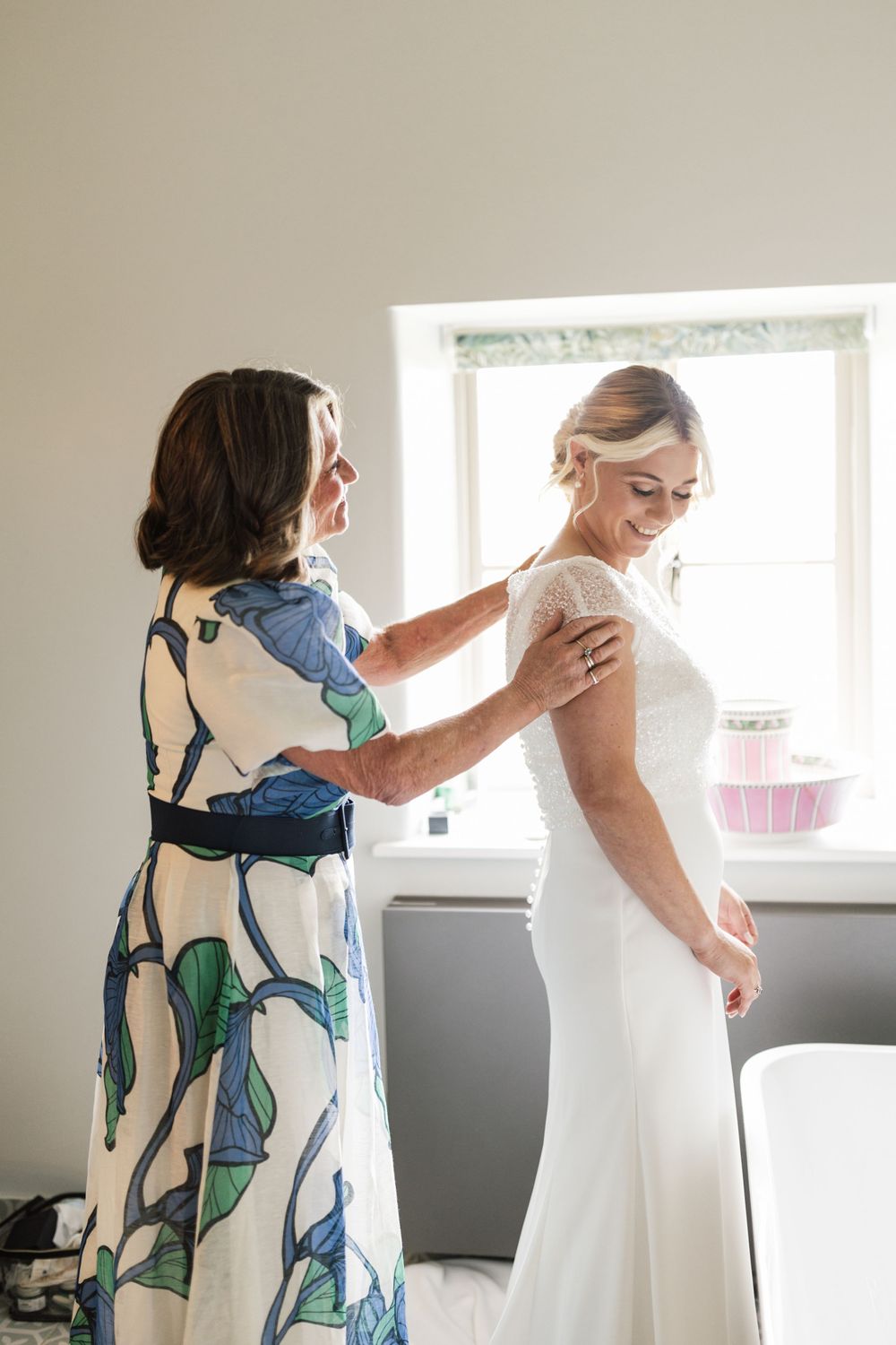 Wedding dress fitting session showing final adjustments being made to a white gown.
