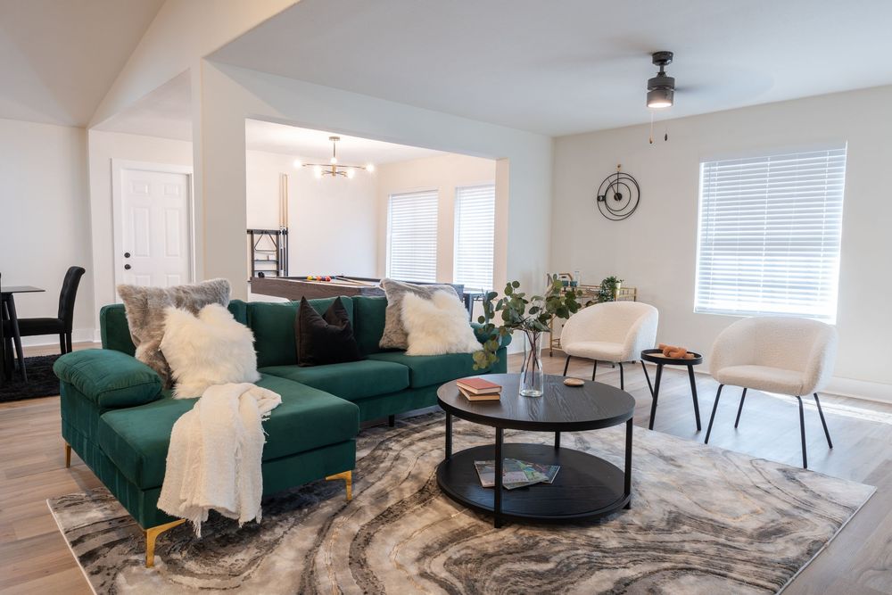 Contemporary living room featuring emerald green sofa and marble pattern rug.