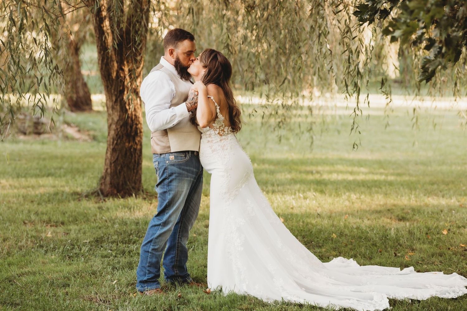 Romantic wedding portraits in a serene meadow setting with natural sunlight filtering through trees in western Maryland.