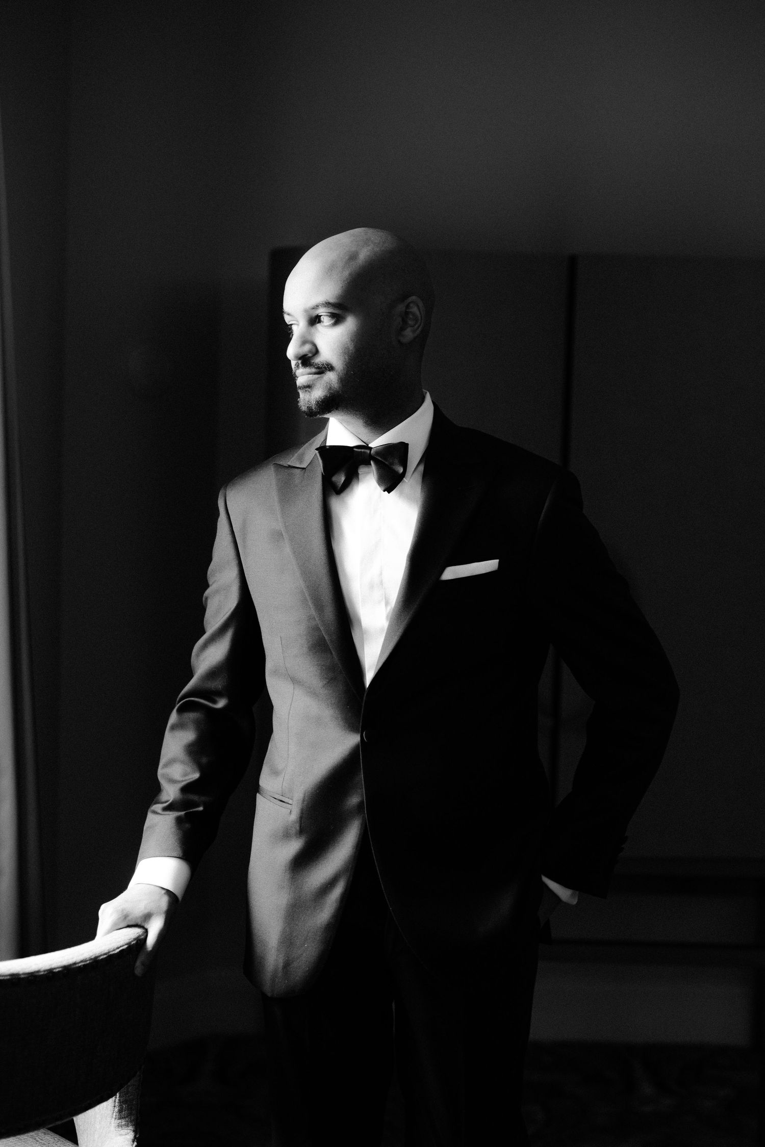 Dramatic black and white portrait series showing a man in a tuxedo and sunglasses posing against dark backgrounds.