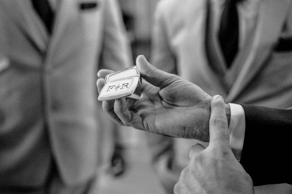 Medical professional wearing white coat holds a small glass vial while preparing medication in a clinical setting.