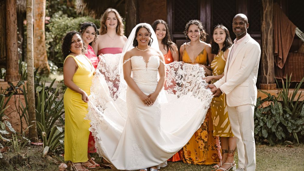 A joyful wedding celebration with guests in formal attire dancing and mingling outdoors at a rustic venue.