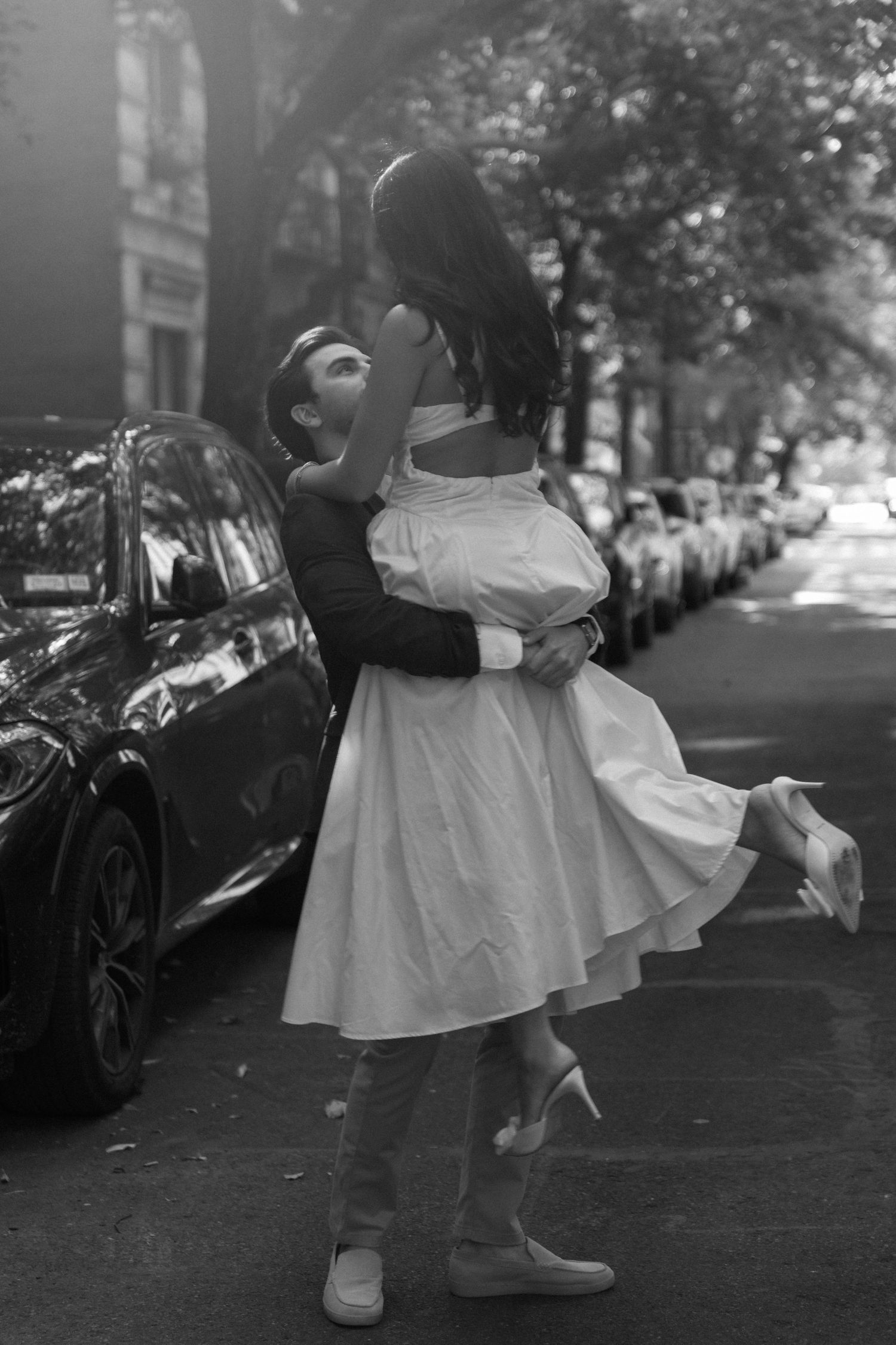 A black and white photo sequence shows a couple dancing together on a street lined with parked cars.