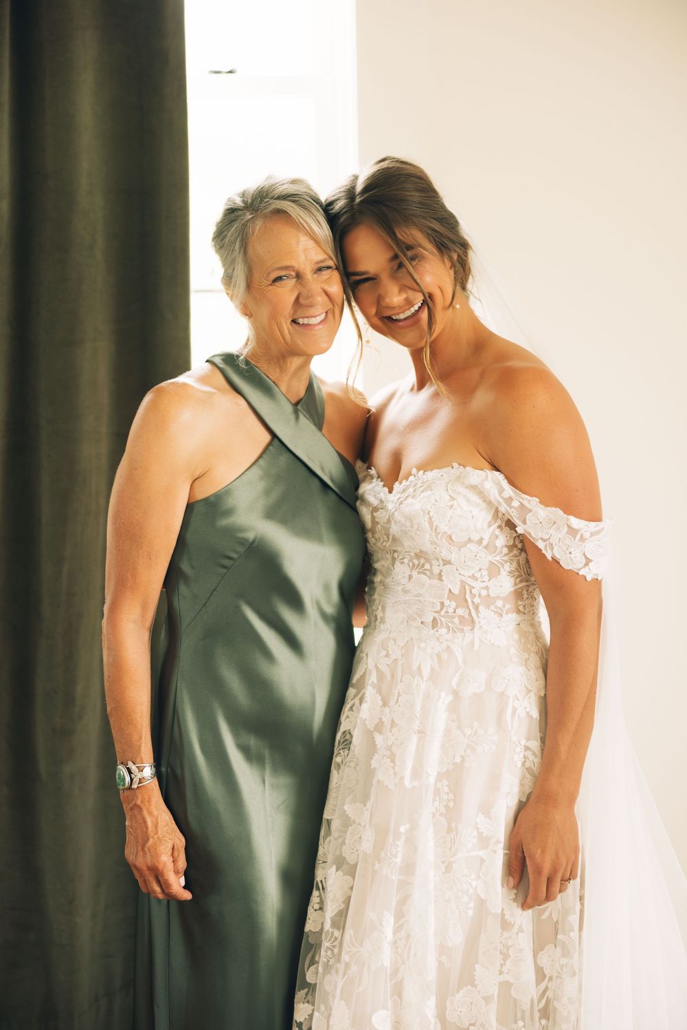 Two people share an intimate moment while wearing formal attire in a bright indoor setting.