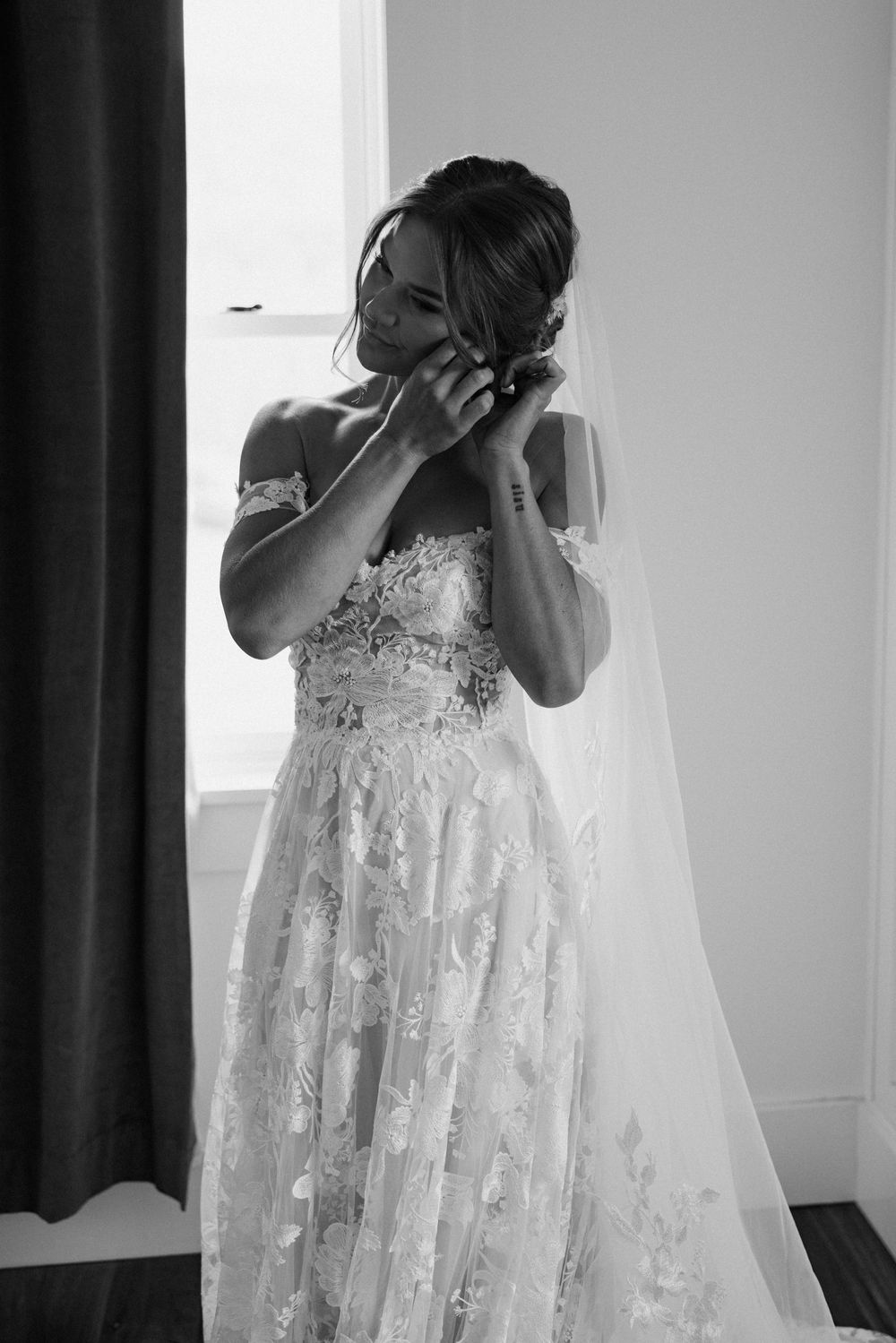 An elegant lace wedding dress with intricate floral details and flowing veil.