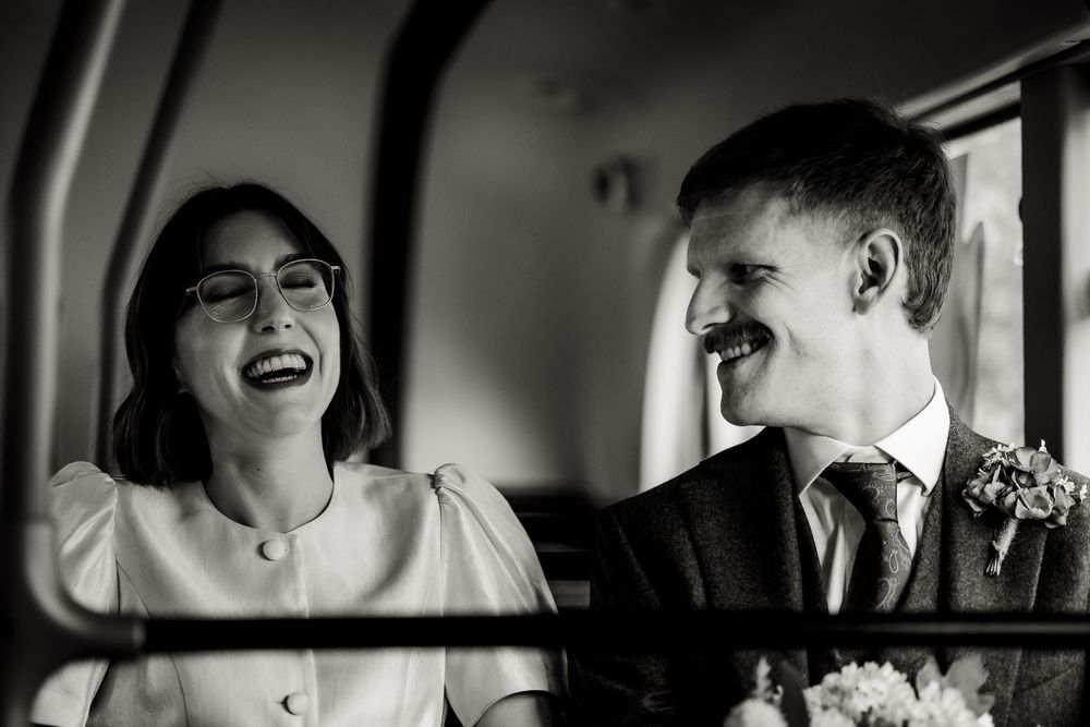 A joyful candid moment captured in black and white showing laughter and celebration in a car.