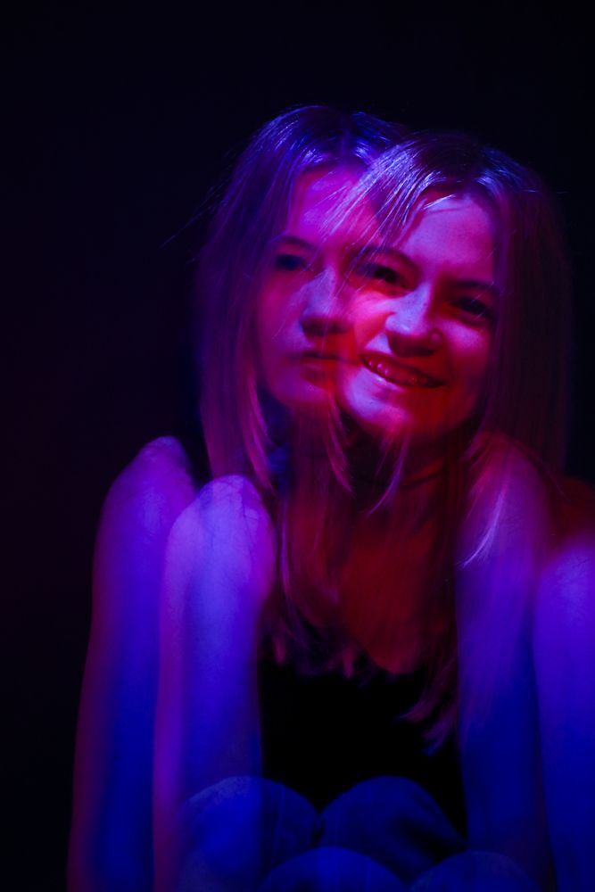 Atmospheric portrait bathed in vibrant purple and pink neon lighting creating dreamy mood.