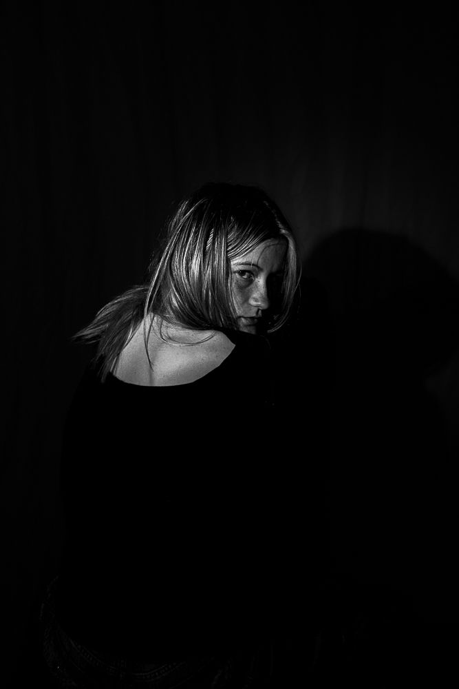 Dramatic black and white portrait series with strong shadows and contrast.